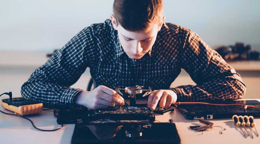 Technician repairing a laptop circuit board for Auckland computer repair